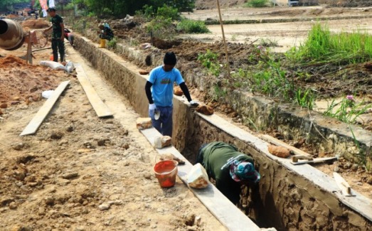 proses plester drainase oleh prajutit dan warga setempat dalam rangka TMMD ke-120 di Kota Bontang